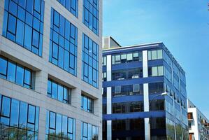 Glass building with transparent facade of the building and blue sky. Structural glass wall reflecting blue sky. Abstract modern architecture fragment. Contemporary architectural background. photo