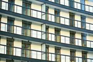 New apartment building with glass balconies. Modern architecture houses by the sea. Large glazing on the facade of the building. photo