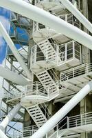 a white metal structure with stairs and a blue sky photo