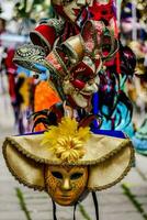 a group of colorful carnival masks hanging from a pole photo