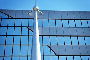 Glass building with transparent facade of the building and blue sky. Structural glass wall reflecting blue sky. Abstract modern architecture fragment. Contemporary architectural background. photo