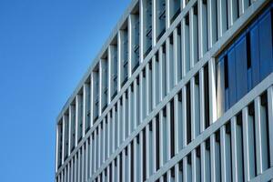 moderno oficina edificio en el ciudad con ventanas y acero y aluminio paneles pared. contemporáneo comercial arquitectura, vertical convergente geométrico líneas. foto