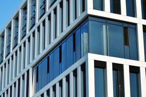 Modern office building in the city with windows and  steel and aluminum panels wall. Contemporary commercial architecture, vertical converging geometric lines. photo