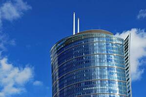 Glass building with transparent facade of the building and blue sky. Structural glass wall reflecting blue sky. Abstract modern architecture fragment. Contemporary architectural background. photo