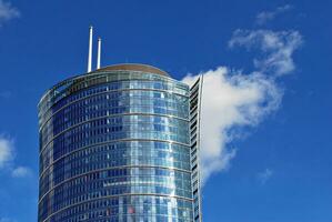 Glass building with transparent facade of the building and blue sky. Structural glass wall reflecting blue sky. Abstract modern architecture fragment. Contemporary architectural background. photo