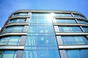 Glass building with transparent facade of the building and blue sky. Structural glass wall reflecting blue sky. Abstract modern architecture fragment. Contemporary architectural background. photo