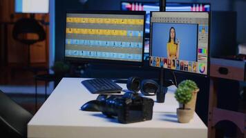 Freelancer personal studio desk with computer screens used for photo processing, graphic tablet and professional camera. Photography gear on table used by photographer, panning shot video