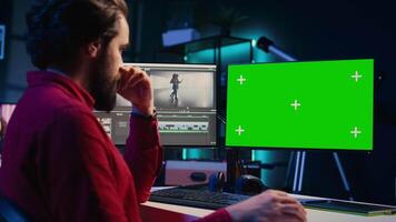 video editor analyseren film montage Aan geïsoleerd scherm Scherm voordat bewerken kleur beoordelen en verlichting in creatief kantoor. post productie studio werknemer werken met rauw beeldmateriaal Aan chroma sleutel pc