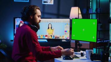 Inhalt Spezialist mit Grafik Design Kompetenzen zu machen Sozial Medien Post auf Grün Bildschirm Computer zum Werbung Unternehmen. Foto Editor mit Chroma Schlüssel pc Monitor zu erstellen Werbung Bild video