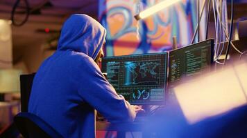 African american hooded hacker hiding in underground base, anxiously looking around for threats, feeling nervous after stealing data from victims using virus, trying hard to evade law enforcement photo