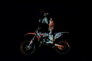 a person riding a dirt bike in the dark photo