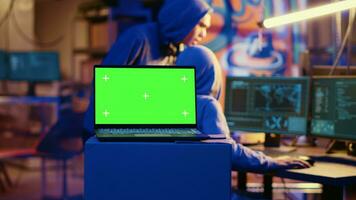 Green screen laptop in bunker with graffiti walls left behind by hackers to act as decoy. Mockup device running script pinging wrong location to cybercriminal law enforcement chasing them photo