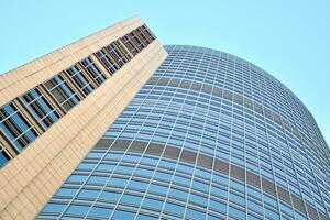 Glass building with transparent facade of the building and blue sky. Structural glass wall reflecting blue sky. Abstract modern architecture fragment. Contemporary architectural background. photo