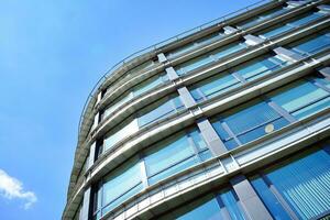 Glass building with transparent facade of the building and blue sky. Structural glass wall reflecting blue sky. Abstract modern architecture fragment. Contemporary architectural background. photo