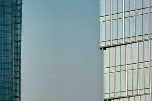 Glass building with transparent facade of the building and blue sky. Structural glass wall reflecting blue sky. Abstract modern architecture fragment. Contemporary architectural background. photo