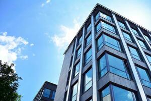 Glass building with transparent facade of the building and blue sky. Structural glass wall reflecting blue sky. Abstract modern architecture fragment. Contemporary architectural background. photo