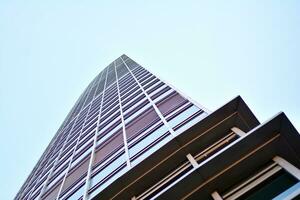 Glass building with transparent facade of the building and blue sky. Structural glass wall reflecting blue sky. Abstract modern architecture fragment. Contemporary architectural background. photo