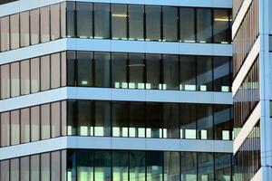 Glass building with transparent facade of the building and blue sky. Structural glass wall reflecting blue sky. Abstract modern architecture fragment. Contemporary architectural background. photo