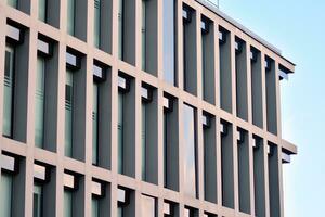 Glass building with transparent facade of the building and blue sky. Structural glass wall reflecting blue sky. Abstract modern architecture fragment. Contemporary architectural background. photo