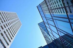 Glass building with transparent facade of the building and blue sky. Structural glass wall reflecting blue sky. Abstract modern architecture fragment. Contemporary architectural background. photo