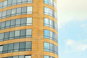 Glass building with transparent facade of the building and blue sky. Structural glass wall reflecting blue sky. Abstract modern architecture fragment. Contemporary architectural background. photo