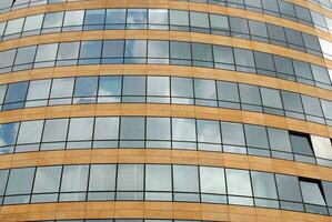 Glass building with transparent facade of the building and blue sky. Structural glass wall reflecting blue sky. Abstract modern architecture fragment. Contemporary architectural background. photo