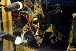 a venetian mask is displayed in a window photo