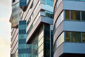 Glass building with transparent facade of the building and blue sky. Structural glass wall reflecting blue sky. Abstract modern architecture fragment. Contemporary architectural background. photo