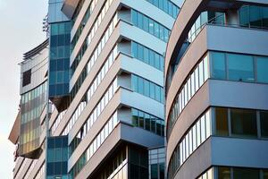 Glass building with transparent facade of the building and blue sky. Structural glass wall reflecting blue sky. Abstract modern architecture fragment. Contemporary architectural background. photo