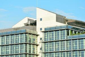 Glass building with transparent facade of the building and blue sky. Structural glass wall reflecting blue sky. Abstract modern architecture fragment. Contemporary architectural background. photo