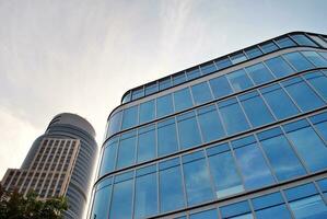 Glass building with transparent facade of the building and blue sky. Structural glass wall reflecting blue sky. Abstract modern architecture fragment. Contemporary architectural background. photo