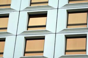 moderno oficina edificio en el ciudad con ventanas y acero y aluminio paneles pared. contemporáneo comercial arquitectura, vertical convergente geométrico líneas. foto