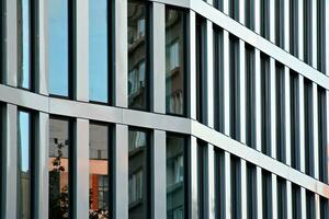 Modern office building in the city with windows and  steel and aluminum panels wall. Contemporary commercial architecture, vertical converging geometric lines. photo