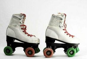 two roller skates with green wheels and red wheels photo