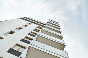 New apartment building with glass balconies. Modern architecture houses by the sea. Large glazing on the facade of the building. photo