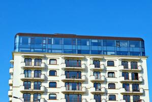 New apartment building with glass balconies. Modern architecture houses by the sea. Large glazing on the facade of the building. photo