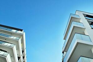 New apartment building with glass balconies. Modern architecture houses by the sea. Large glazing on the facade of the building. photo