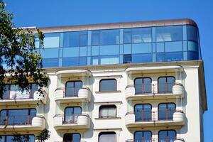 New apartment building with glass balconies. Modern architecture houses by the sea. Large glazing on the facade of the building. photo