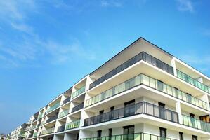 New apartment building with glass balconies. Modern architecture houses by the sea. Large glazing on the facade of the building. photo