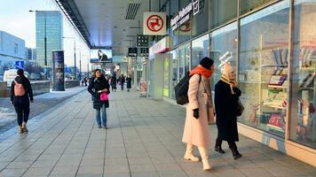 Warsaw, Poland. 5 December 2023. Residents and guests walk along the central street of city. People on sidewalk on with shops. photo