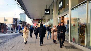 Warsaw, Poland. 5 December 2023. Residents and guests walk along the central street of city. People on sidewalk on with shops. photo