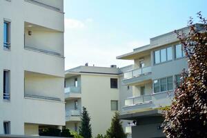 New apartment building with glass balconies. Modern architecture houses by the sea. Large glazing on the facade of the building. photo