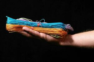 a person holding a stack of colorful string photo