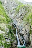 a waterfall in the mountains photo