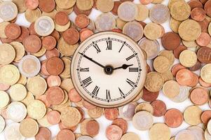 a clock is surrounded by coins photo