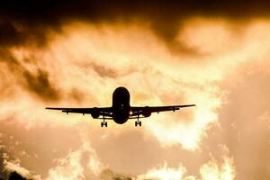 an airplane is flying through the sky at sunset photo