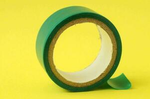 a roll of green tape on a yellow background photo