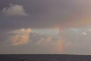 a cloudy sky above an ocean photo