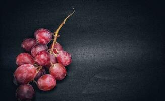 un puntilla de uvas estaba fotografiado con el concepto de dando un ligero efecto a el uvas, negativo espacio. foto