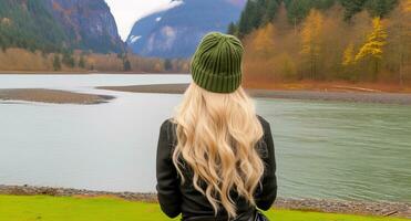AI generated Female hiker in winter hat enjoying calm lake view. Generative AI photo